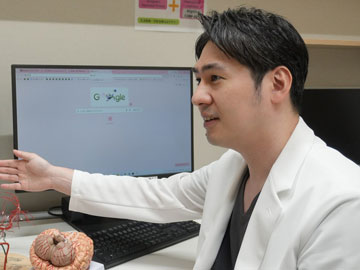 診察室で説明する院長