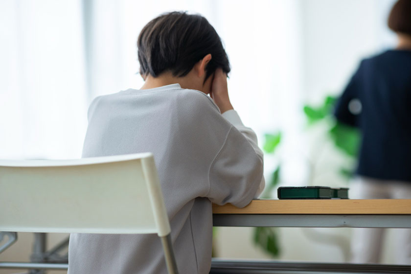 机で頭を抱える子どものイメージ