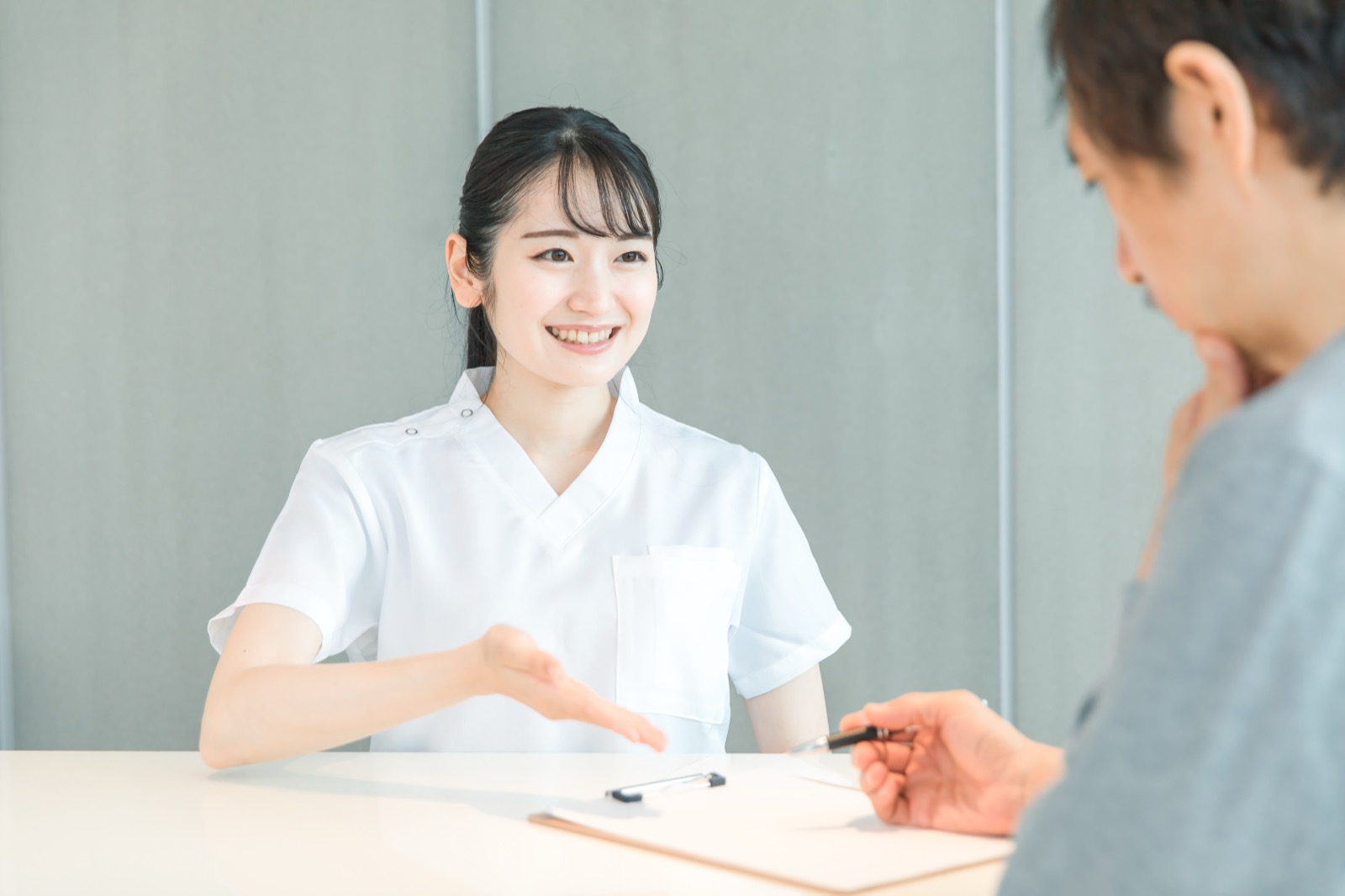 看護師が患者さんに頭痛の生活面のサポートを説明している様子